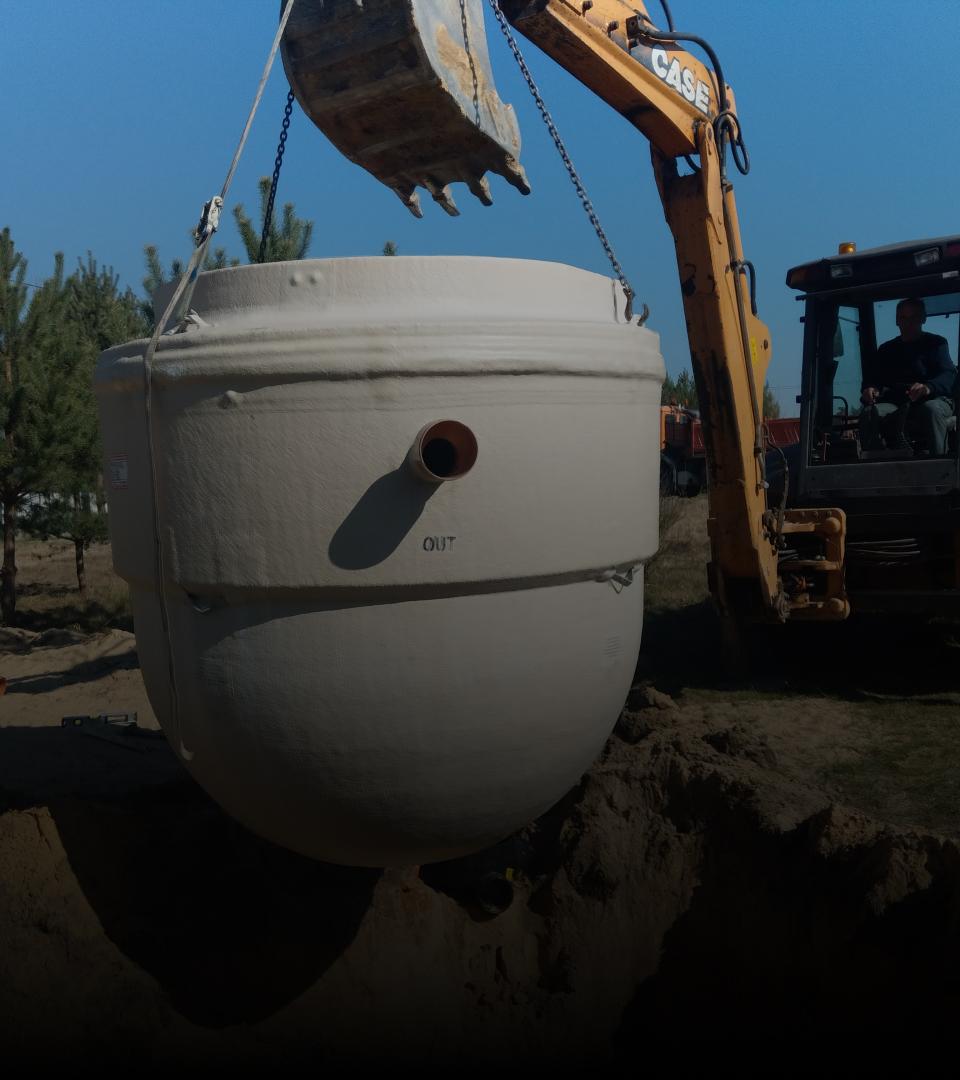 Zdjęcie koparki umieszczającej zbiornik w ziemi